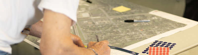 Transportation Planning - Alliant Engineering. Photo of person writing notes of a plan sheet.